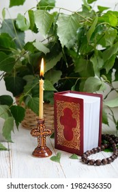 candle, rosary beads, birch leaves, bible books. Holy Trinity Sunday. festive traditional composition for Pentecost day. concept of faith, God, orthodox Church, lent, religion. 