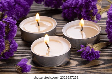 Candle. Tea Lights Candle. Mini Tealight candles for home decoration. Flowers on wooden table. Dripless and long lasting paraffin or white beeswax. Good for essential oil diffuser or aroma lamps.