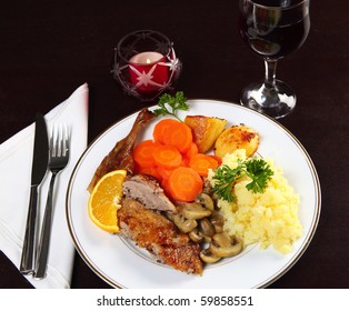 A Candle-lit Dinner Of Roast Duck, Potatoes, Carrots And Mushrooms With Wine.