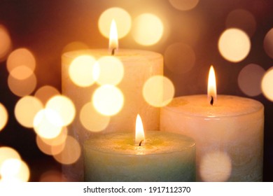 Candles burning light in a church background
