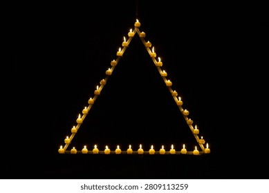 Candles are burning in a triangle in a dark studio          