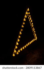 Candles are burning in a triangle in a dark studio          