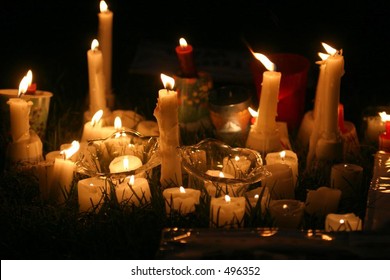 Candles In The Grass At A Park During A Candle Lit Vigil.