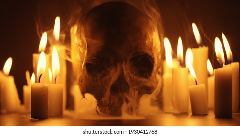 Candles and human skull in darkness close up - Shutterstock ID 1930412768