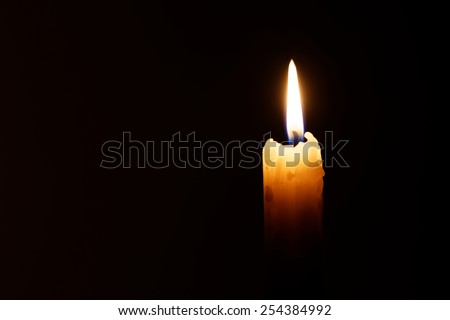 The candle's image is isolated against a black background and fades into a shadow. 