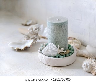 The candlestick with a light green candle, decorated with seashells, stones and corals.