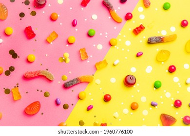 Candy assorted layout. Layout with candy on a yellow-pink background. Chewy marmalade and small caramels . Bright background. Sweets for every taste. An article about sweets.