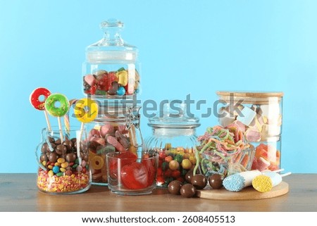 Candy bar. Many different sweets on wooden table against light blue background