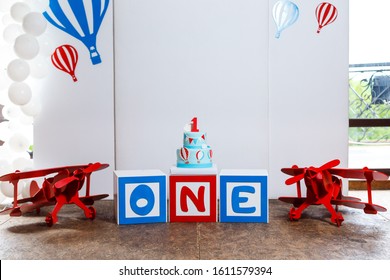 Candy bar on boy's birthday party with a lot of different candies, popcorn, beverages and big cake. Decorated in blue,red and white colors, balloons or aviation theme, indoor