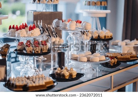 Candy bar on wedding feast closeup. Delicious reception luxury ceremony. Table with sweets, candies, and dessert. Tasty colorful french macaroons on a plate. Culinary and cooking concepts.