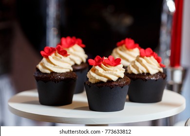 Candy Bar On Woman's Birthday Party With A Lot Of Different Candies, Cupcakes And Big Cake, Standing On Barrels In Black,red, White Colors. Paris Theme, Indoor