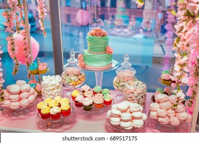 Candy Bar in pinky colors. Delicious sweet buffet with cupcakes and wedding cake. Sweet holiday buffet with marshmallows and other desserts.