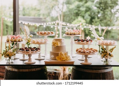 Candy bar at a wedding with different sweets and a wedding cake, in pastel colors.