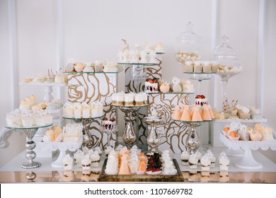 Candy Bar. White Wedding Cake Decorated By Flowers Standing Of Festive Table With Deserts, Strawberry Tartlet And Cupcakes. Wedding. ReceptionTartlets