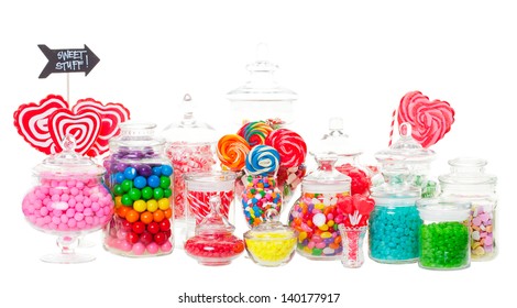 A candy buffet with a wide variety of candies in apothecary jars.  Shot on white background. - Powered by Shutterstock