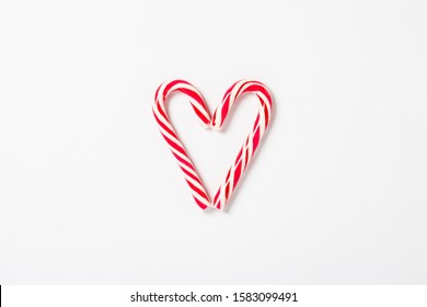 Candy caramel cane in the form of a heart on a white background. Concept Christmas, New Year, minimalism. Flat lay, top view - Powered by Shutterstock