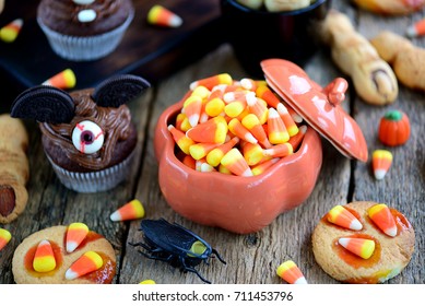 Candy corn with chocolate cupcakes "bats" and shortbread cookies "witch's fingers" -  delicious sweets for the celebration of Halloween. - Powered by Shutterstock