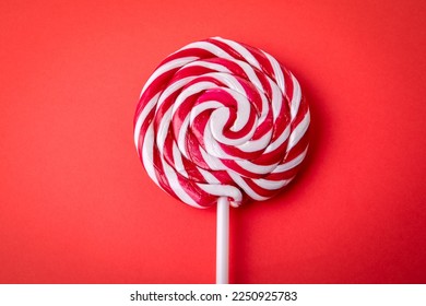 Candy on a stick, lollipop. Red background. - Powered by Shutterstock