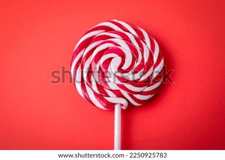 Candy on a stick, lollipop. Red background.