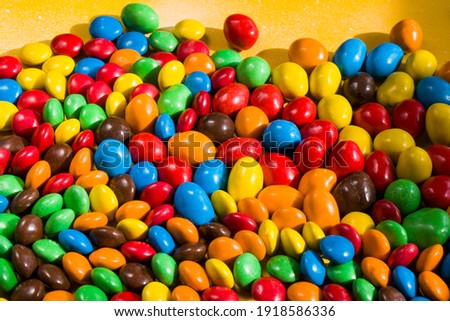 Candy on the yellow background, colorful candy and multicolored gradient