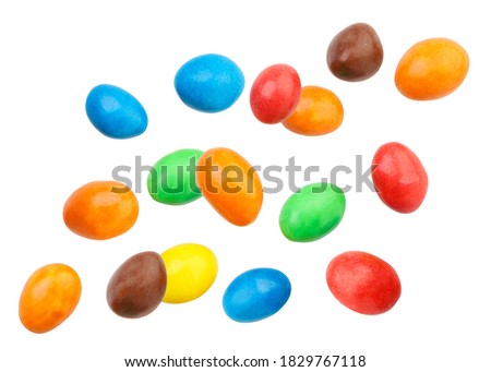 Candy peanuts covered with chocolate in a multicolored glaze fly on a white background. Isolated