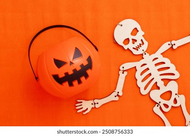 Candy pumpkin and halloween skeleton on an orange background - Powered by Shutterstock