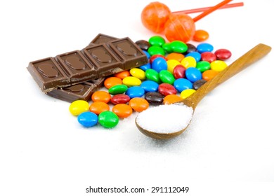 Candy ,sugar,chocolate And Sweets On White Background.Sugar In The Wooden Spoon.Colorful Candy.Unhealthy Weight Gain And Bad For Body. Version 3.