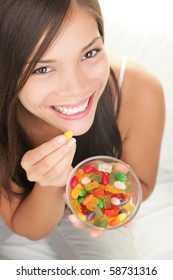 Candy Woman. Girl Eating Winegum Gummy Bears And Other Sweets Smiling Looking At Camera.