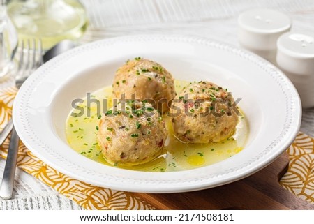Canederli or Knodel in broth with green onion, typical pasta or dumplings for Alps, Alto Adige, German, Italian, Austrian cuisine. Made from stale bread, milk, eggs, speck.	