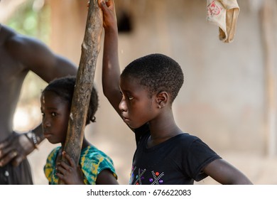 CANHABAQUE, GUINEA BISSAU - MAY 4, 2017: Unidentified local little girls lean on the wooden pole in a village of the Canhabaque island. People in G.-Bissau still suffer of poverty - Shutterstock ID 676622083
