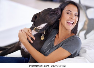 Canine Companion. Shot Of An Attractive Young Woman Enjoying A Cuddle With Her Dog At Home.