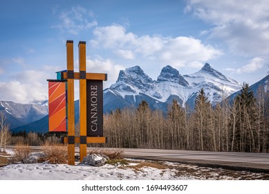 Canmore, Alberta - April 4, 2020: Canmore signage at the entrance to the town of Canmore Alberta with the Three Sisters mountain on the background. 