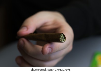 Cannabis blunt or joint close-up. Marijuana rolled in paper. THC drug use