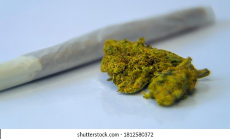 Cannabis buds are on the table. Defocus.
					Marijuana bud close up isolated texture. Cannabis on white paper. BMPCC. Marijuana, weed, drug smoking concept. CBD, THC.
					Preparing cannabis for consumption