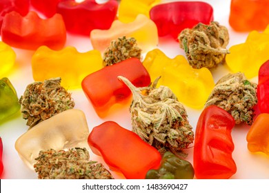 Cannabis Edibles, Medical Marijuana, CBD Infused Gummies And Edible Pot Concept Theme With Close Up On Colorful Gummy Bears And Weed Buds On White Background