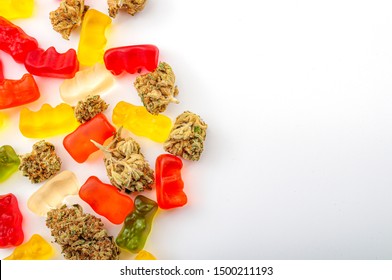 Cannabis Edibles, Medical Marijuana, CBD Infused Gummies And Edible Pot Concept Theme With Close Up On Colorful Gummy Bears And Weed Buds On White Background With Copy Space