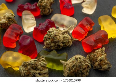 Cannabis Edibles, Medical Marijuana, CBD Infused Gummies And Edible Pot Concept Theme With Close Up On Colorful Gummy Bears And Weed Buds On Dark Background