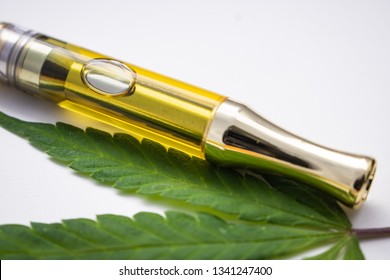 Cannabis Extracted Oil Distillate In Vape Pen Cartridge Up Close With Hemp Leaf 