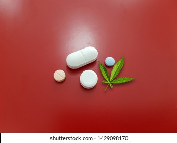 Cannabis Leaf And Medicine On Red Background. Cannabis ( Marijuana ) Is A Psychoactive Drug Used For Medical Purpose As Treatment For Cancer, Parkinson Disease, Seizure, Glaucoma. Medical Concept 