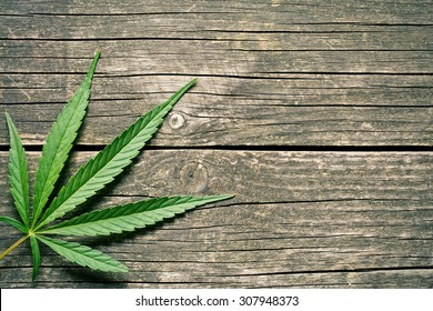 cannabis leaf on old wooden table