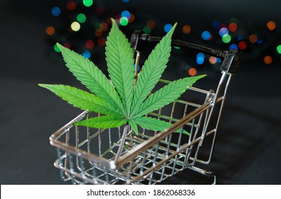 Cannabis Leaf In Shopping Cart. Christmas Lights. Black Friday Sale. Marijuana Delivery 