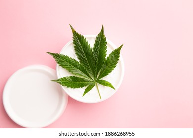 Cannabis Lotion Topical With Marijuana Leaf And Lid On Pink Background