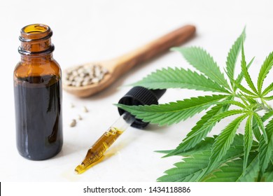 Cannabis oil in dropper with small bottle and cannabis leaves.