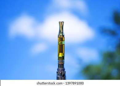 Cannabis Oil, Vape Pen and Blue Sky. Vaping Marijuana THC and CBD 