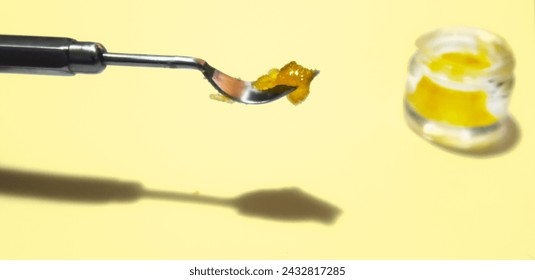 Cannabis Resin Dab on Dab Tool Cannabis Terpene Sauce With Jar Yellow Background Isolated Cannabis Concentrate Extract