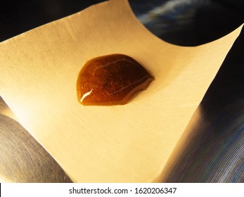 Cannabis Rosin On Parchment Paper On Metal Table