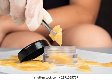 A Cannabis Smoker Holds A Golden Piece Of Wax In His Hands For High Smoking.