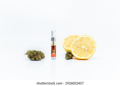 Cannabis vape cartridge and lemons on a white background. Limonene terpene concept.