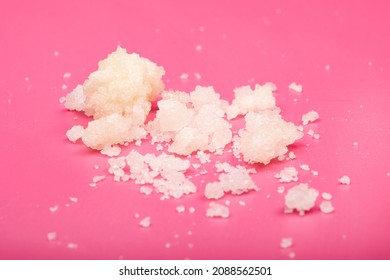 cannabis wax marijuana extract crystals sprinkled on pink background macro.