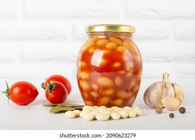 Canned Beans In Tomato Paste In A Glass Jar On A White Table